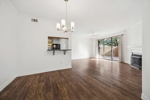 a view of empty room with wooden floor and fireplace