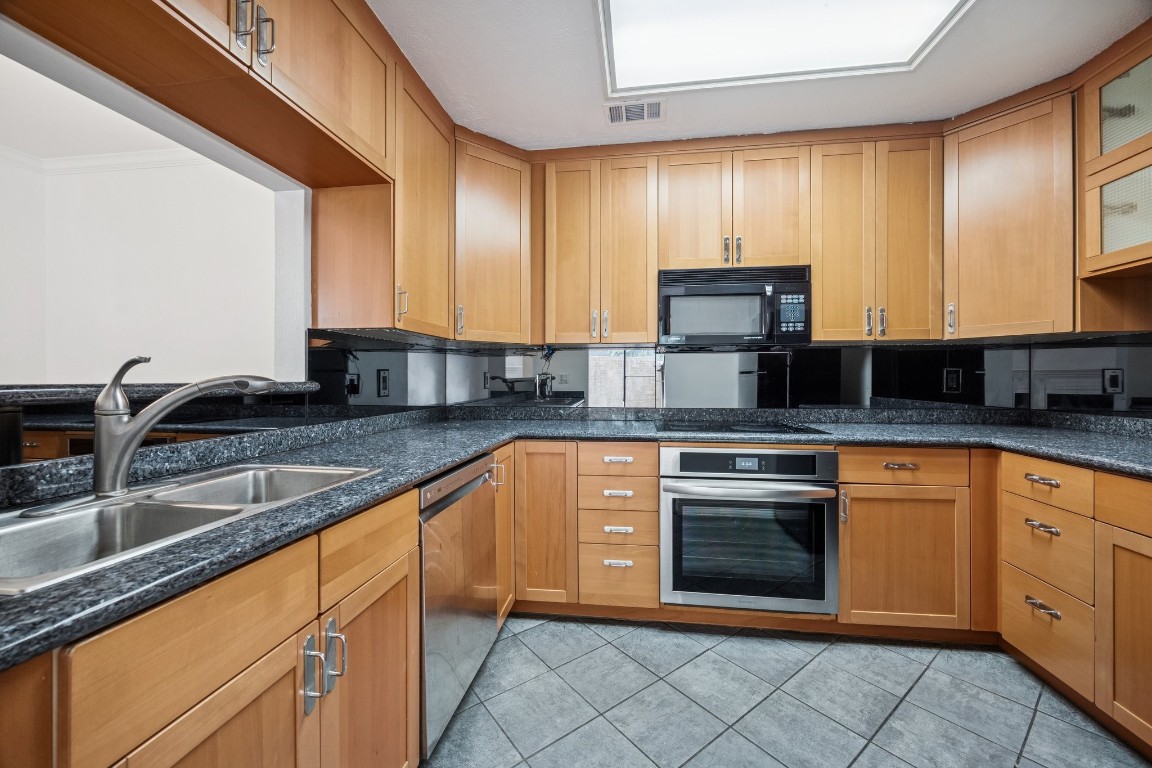 5200 Weslayan Street, Unit 101 Houston, TX 77005 - Photo 8 of 19 a kitchen with stainless steel appliances granite countertop a sink stove and cabinets