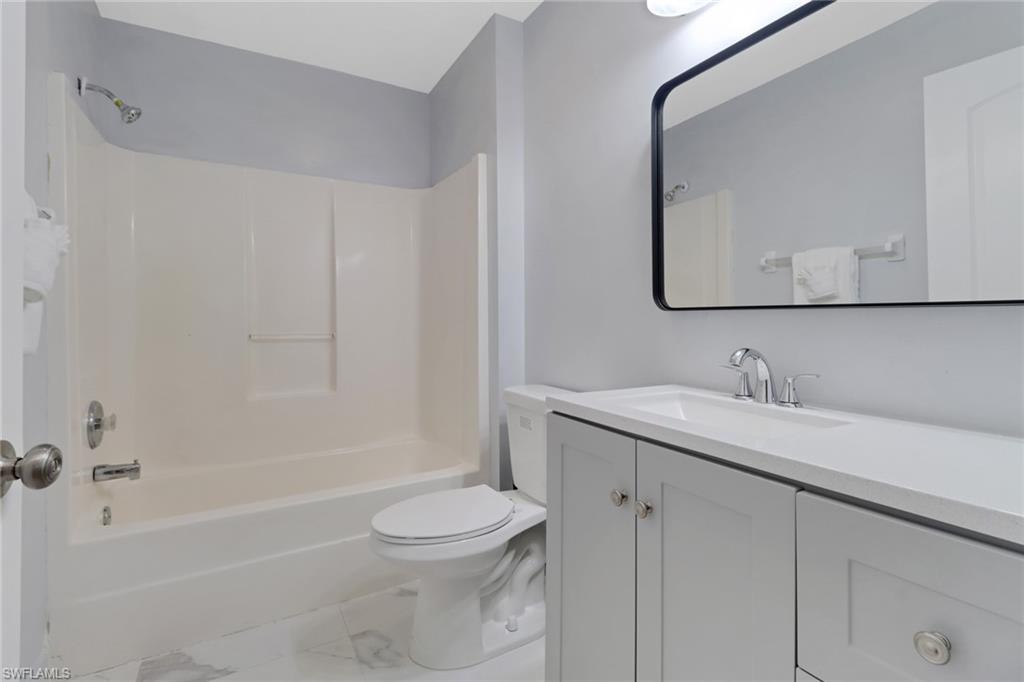 220 Ancona Street Fort Myers, FL 33913 - Photo 17 of 25 a bathroom with a granite countertop sink toilet and shower
