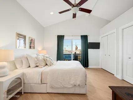 a bedroom with a large bed and a chandelier