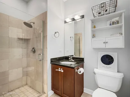 a bathroom with a granite countertop toilet a sink and a shower