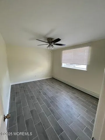 an empty room with a ceiling fan and window