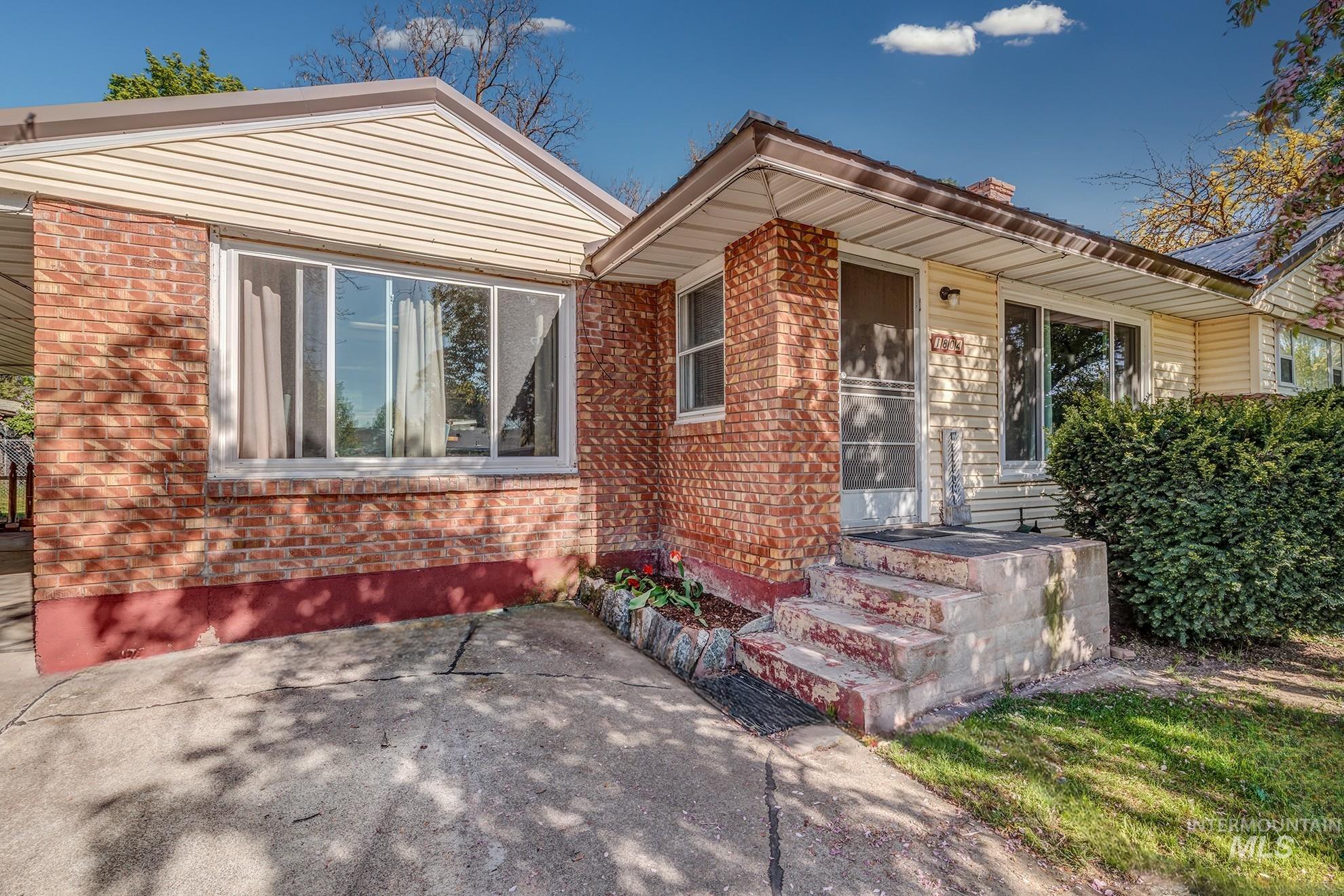 1804 Sunset Street Weiser, ID 83672 - Photo 1 of 1 Exterior featuring a brick and siding facade, covered entry, concrete steps, and a large front window