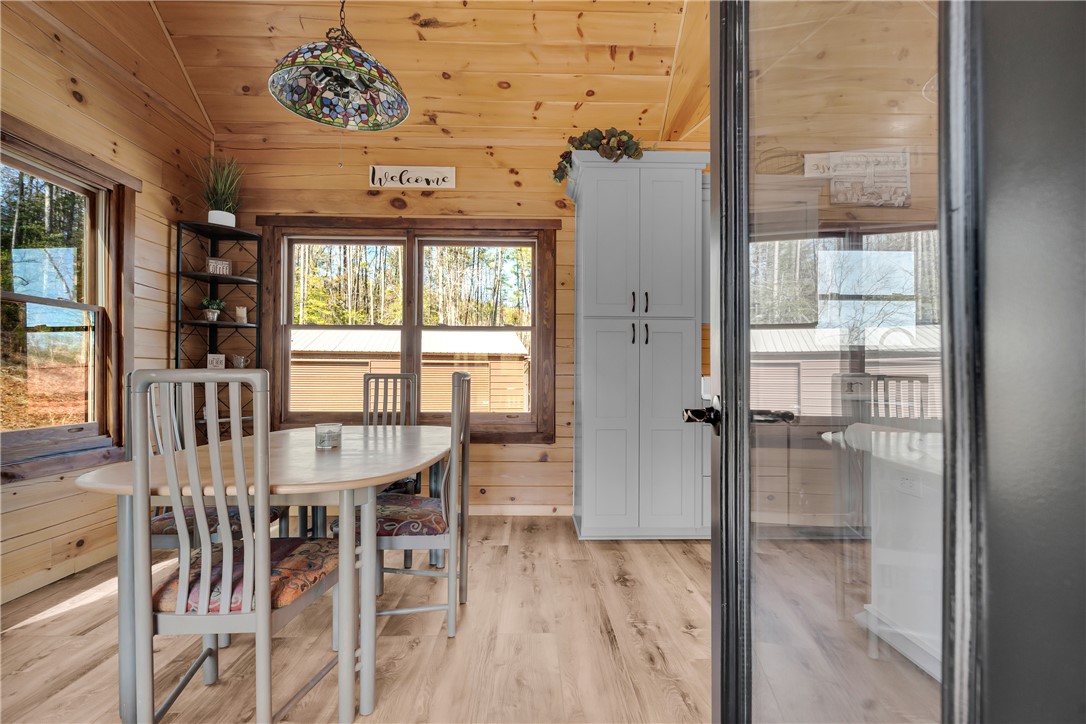 239 North Little River Road Salem, SC 29676 - Photo 12 of 43 This inviting dining area features warm wood paneling, abundant natural light, and durable wood flooring.