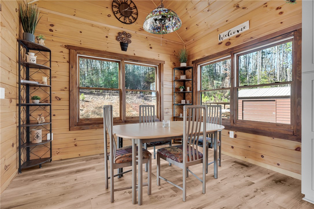 239 North Little River Road Salem, SC 29676 - Photo 15 of 43 This dining area features warm wood-paneled walls and large windows with serene outdoor views.