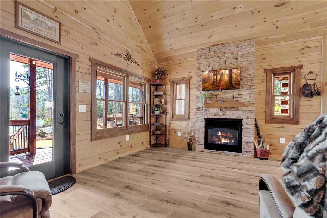 239 North Little River Road Salem, SC 29676 - Photo 24 of 43 This inviting living area boasts rich wood paneling, an elegant fireplace, and serene outdoor views.