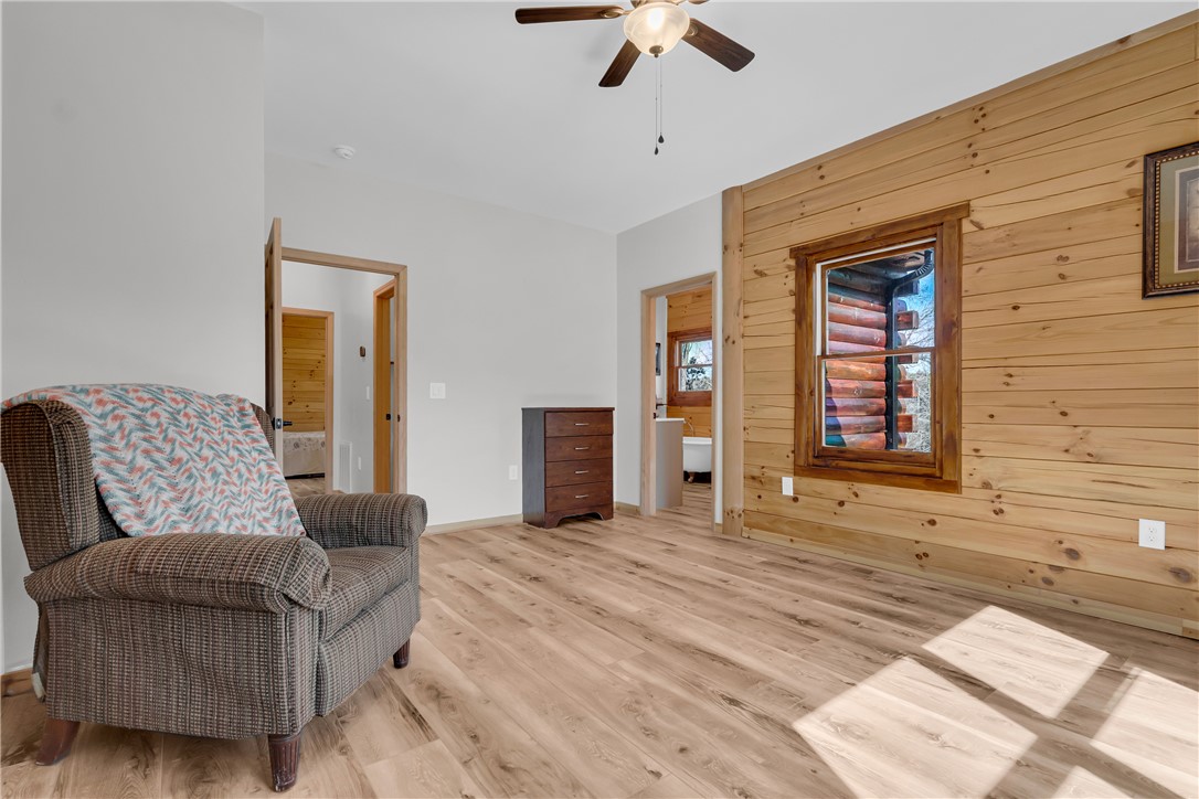 239 North Little River Road Salem, SC 29676 - Photo 27 of 43 This spacious bedroom features warm wood paneling, durable laminate flooring, and an inviting ambiance.
