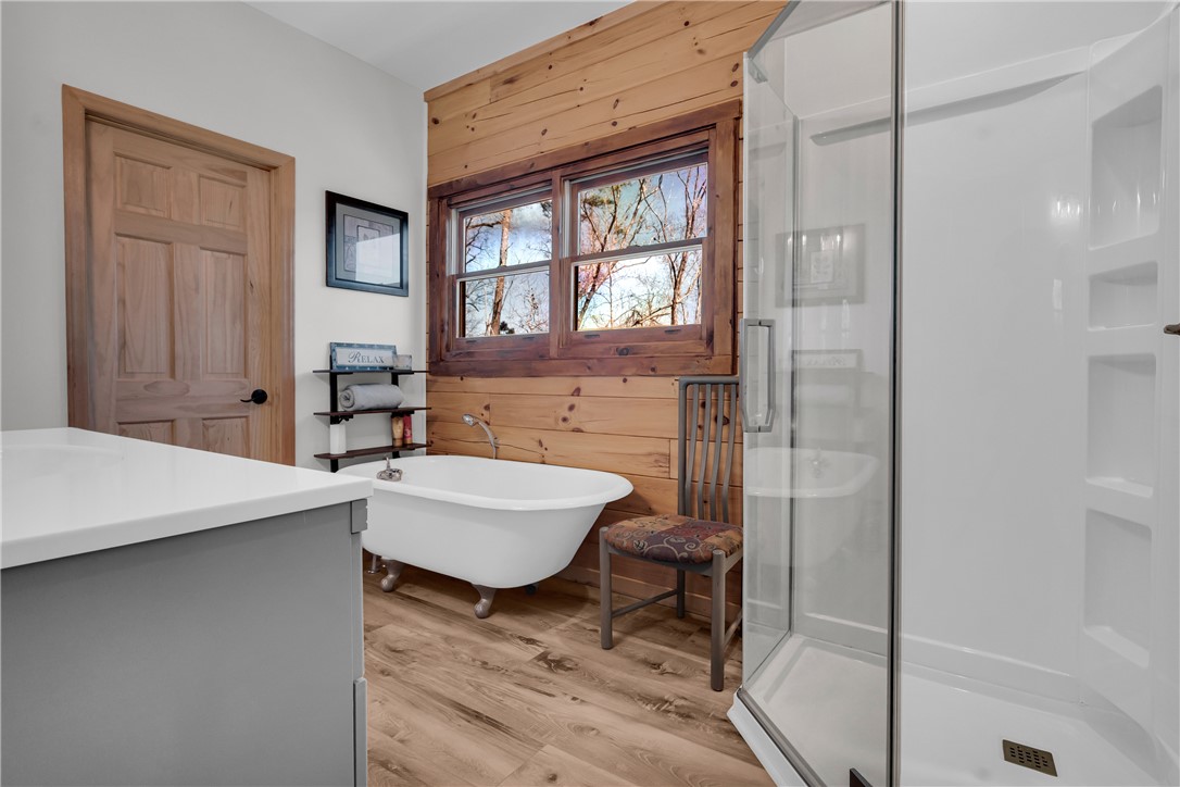 239 North Little River Road Salem, SC 29676 - Photo 29 of 43 This serene bathroom offers a peaceful retreat with a classic soaking tub and modern walk-in shower.