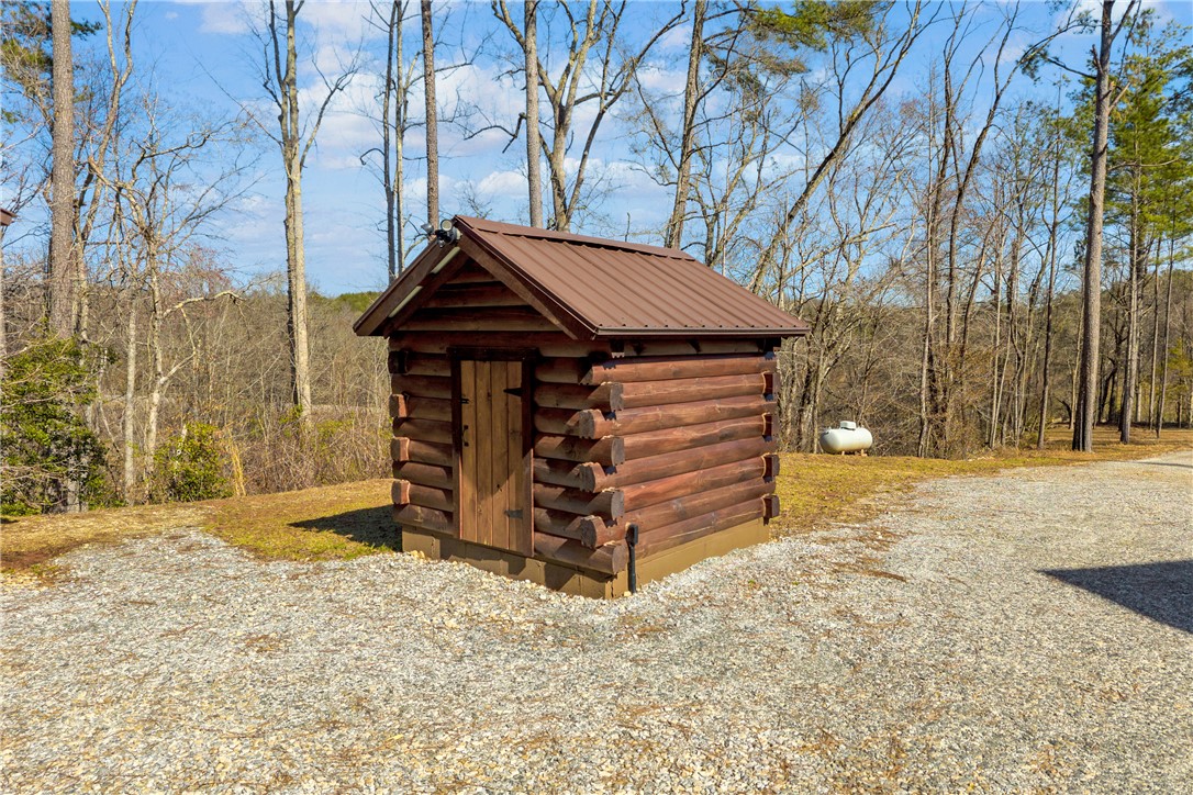 239 North Little River Road Salem, SC 29676 - Photo 34 of 43 This charming log cabin shed offers rustic appeal and practical storage in a serene setting.