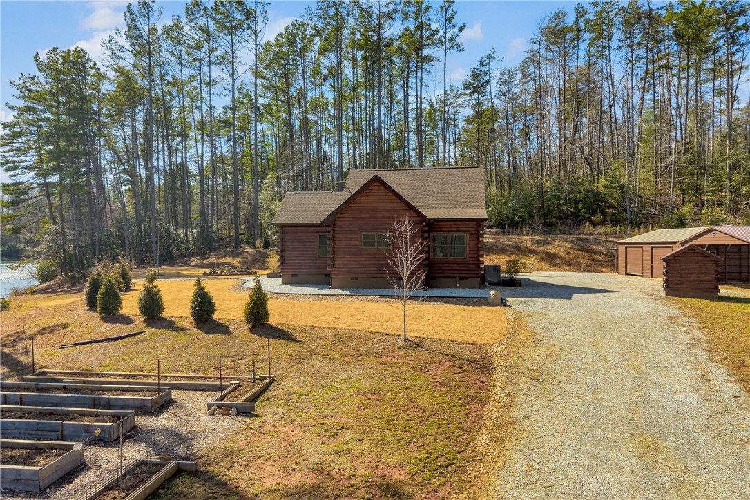 239 North Little River Road Salem, SC 29676 - Photo 6 of 43 This charming retreat offers rustic living amidst nature, featuring a beautiful wood exterior and a private garden.