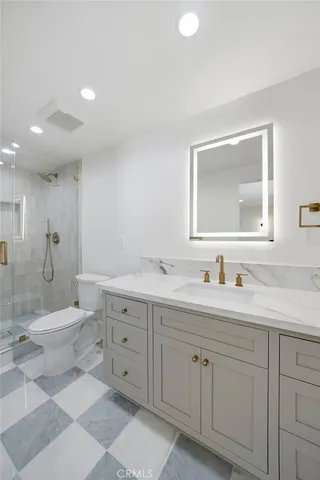 a spacious bathroom with a double vanity sink a toilet and a mirror