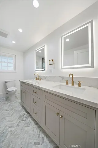 a bathroom with a granite countertop sink mirror and toilet