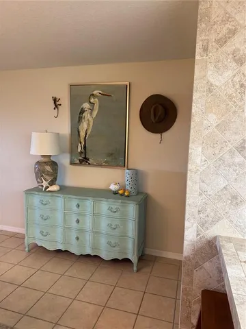 a bed sitting in a bedroom and dresser next to a window