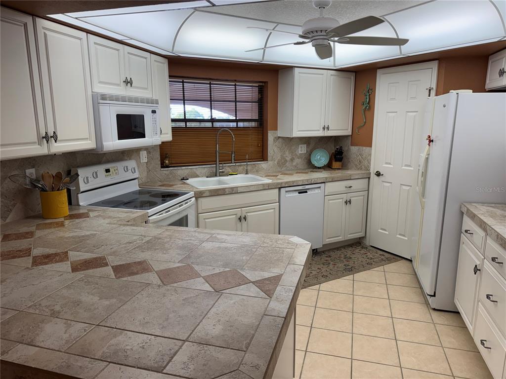 23465 Harbor View Road, Unit 244 Punta Gorda, FL 33980 - Photo 7 of 61 a kitchen with stainless steel appliances a refrigerator sink and cabinets
