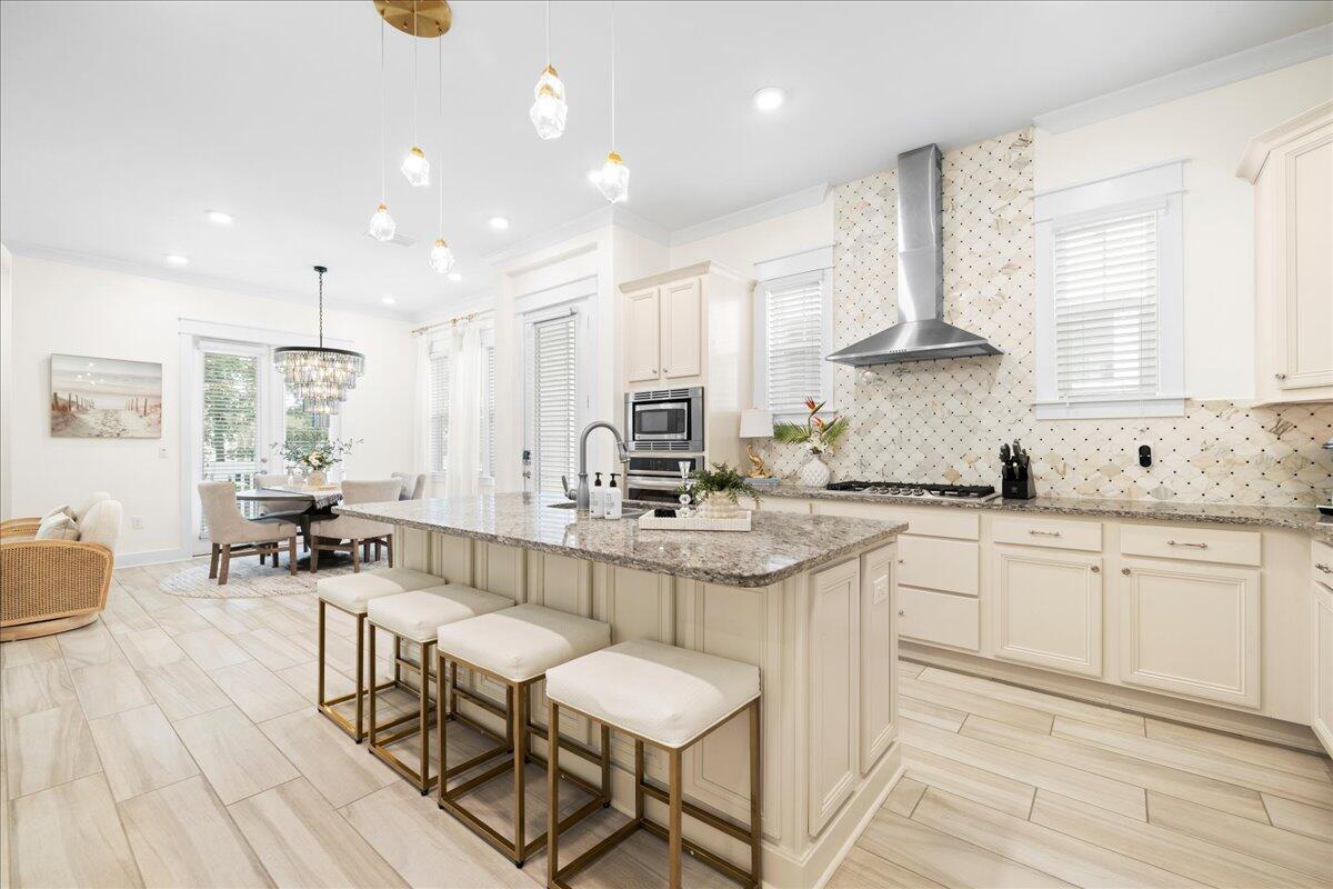 a kitchen with stainless steel appliances granite countertop a table chairs sink and cabinets