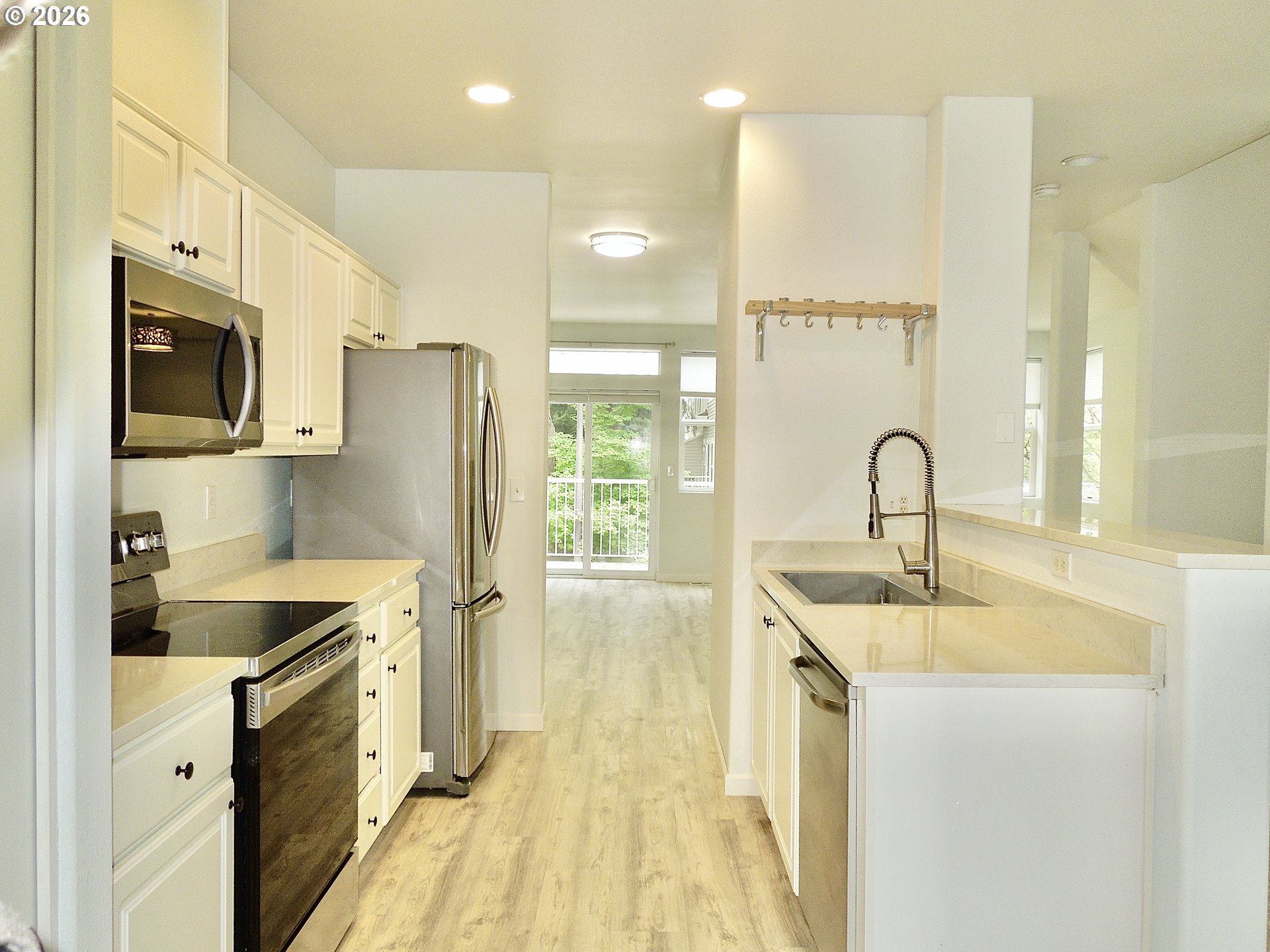 14110 Southwest Barrows Road, Unit 1 Portland, OR 97223 - Photo 6 of 18 a kitchen with stainless steel appliances a sink stove and refrigerator