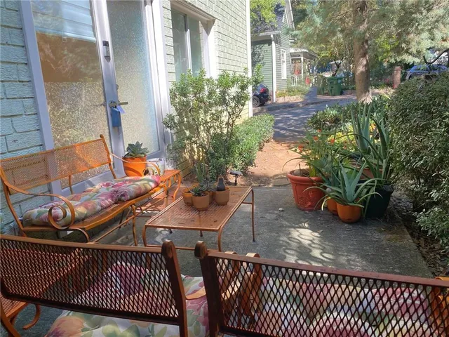 a view of a roof deck with table and chairs potted plants