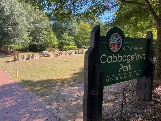 a view of a street sign under a large tree