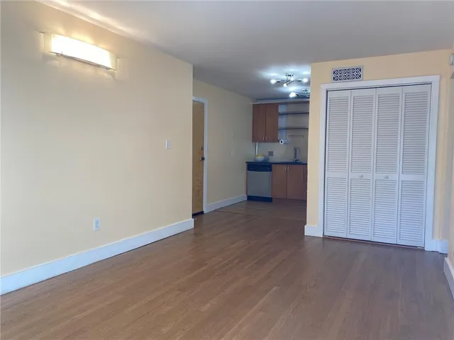 a view of a kitchen with wooden floor and a window