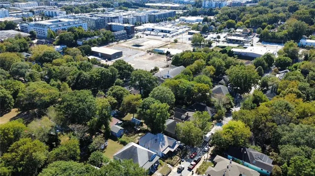 an aerial view of residential houses with outdoor space and trees