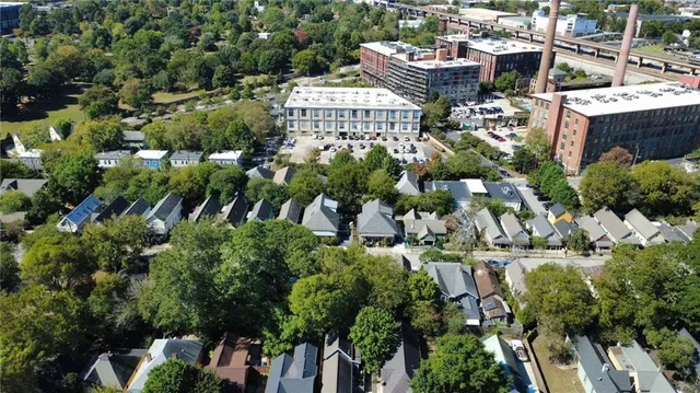 an aerial view of residential houses with outdoor space and trees