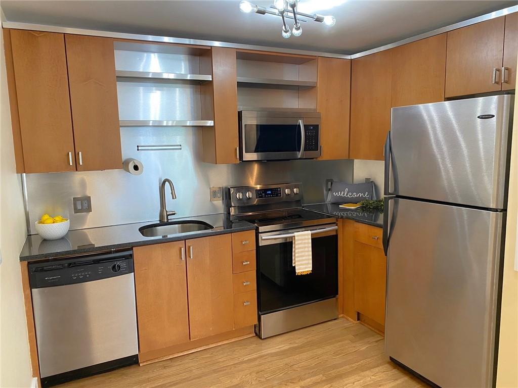 181 Powell Street Southeast, Unit 2 Atlanta, GA 30316 - Photo 8 of 47 a kitchen with stainless steel appliances granite countertop a refrigerator a stove a sink and a microwave