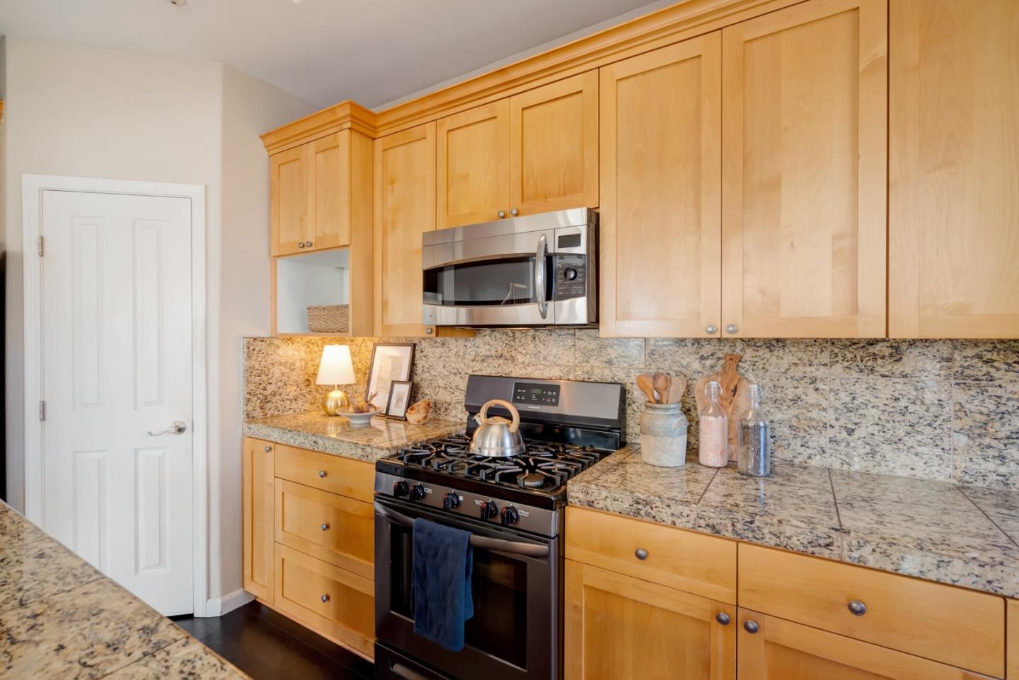 8850 Morey Way Gilroy, CA 95020 - Photo 12 of 34 a kitchen with stainless steel appliances granite countertop white cabinets and a stove top oven
