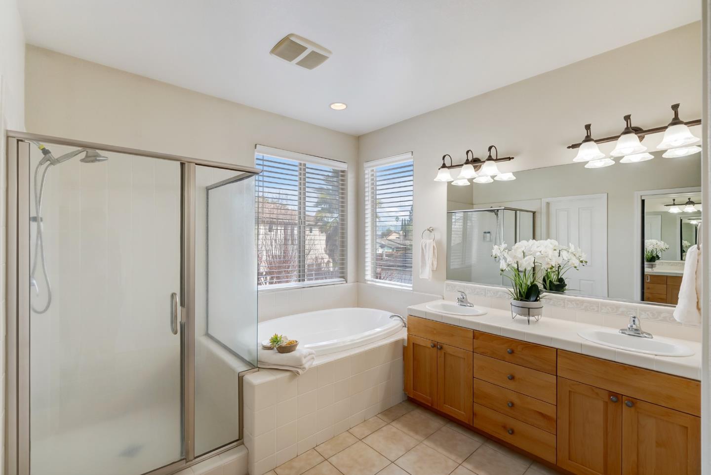 8850 Morey Way Gilroy, CA 95020 - Photo 25 of 34 a bathroom with a granite countertop sink mirror and a bathtub