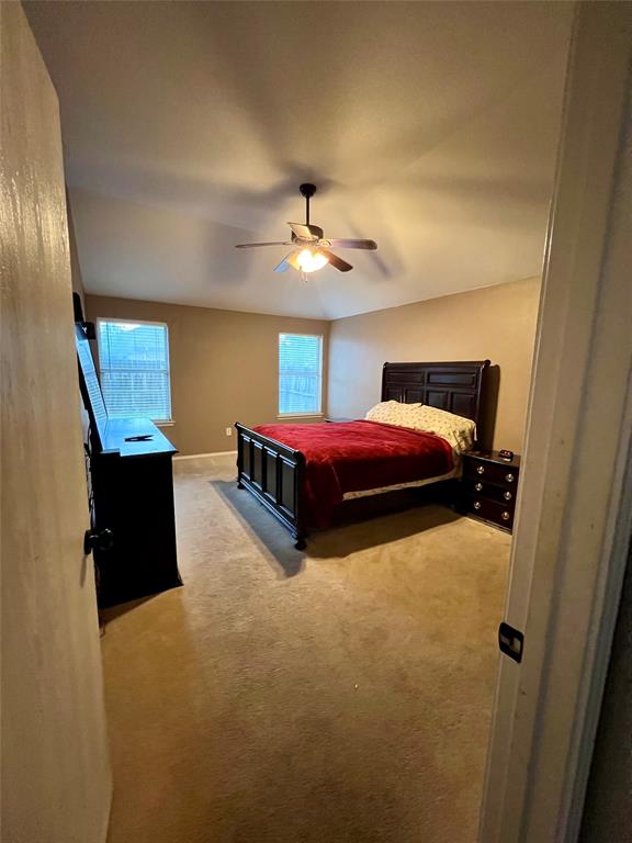 12201 Rolling Ridge Drive Fort Worth, TX 76028 - Photo 12 of 21 Spacious room featuring neutral wall tones, two windows with blinds, and a ceiling fan with integrated lighting