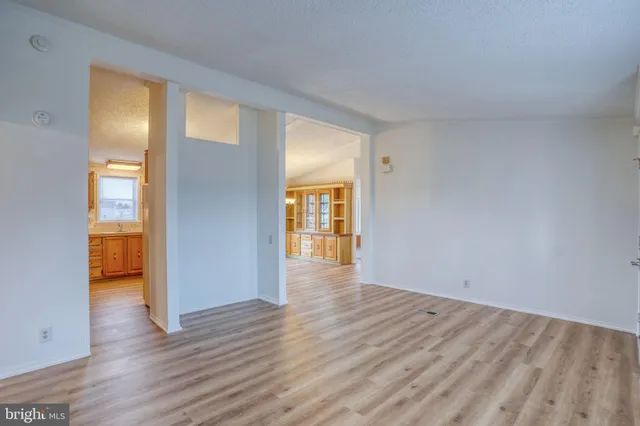 a view of a big room with wooden floor and windows