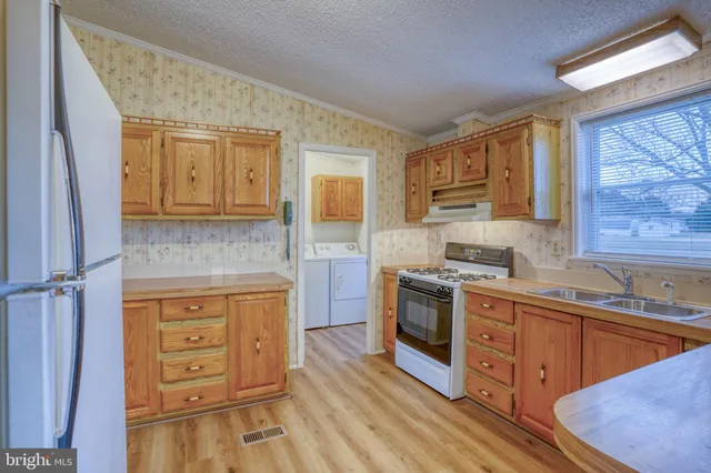 a kitchen with stainless steel appliances granite countertop a sink stove and cabinets
