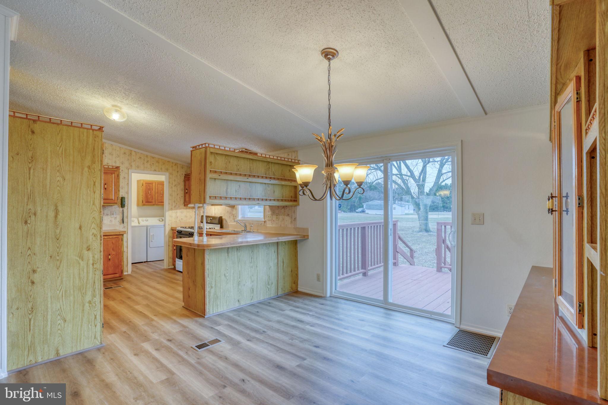 4285 Carpenter Bridge Road Felton, DE 19943 - Photo 26 of 45 a open kitchen with a refrigerator a sink dishwasher a oven and a dining table with wooden floor