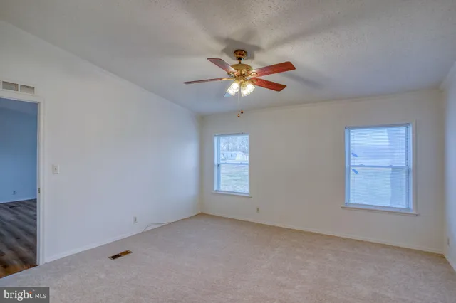 an empty room with a fan and a fan