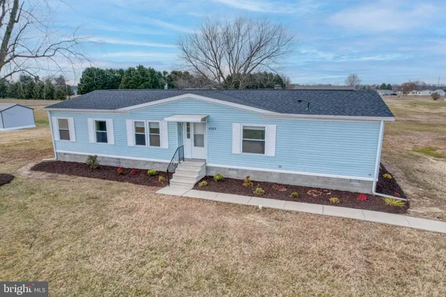 a view of a house with chairs and wooden fence