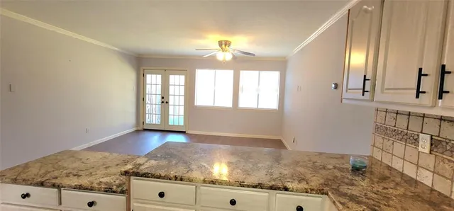 a kitchen with granite countertop a refrigerator and a stove top oven