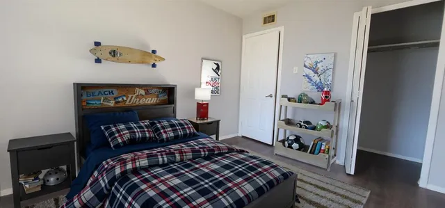 a bedroom with a bed and wooden floor