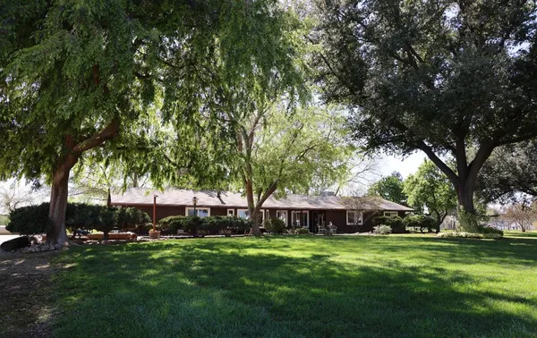a backyard of a house with yard table and chairs