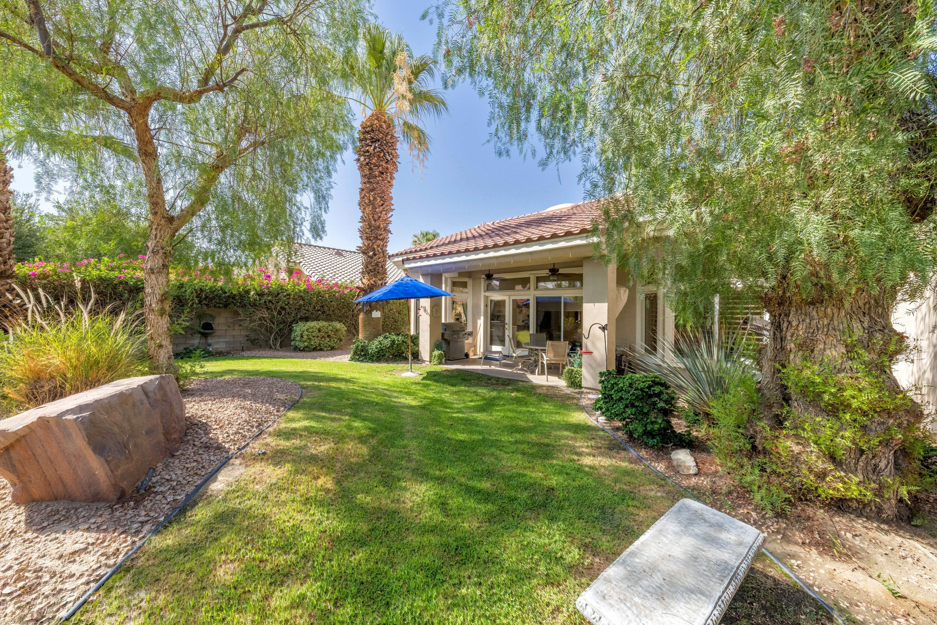 a view of a house with backyard and sitting area
