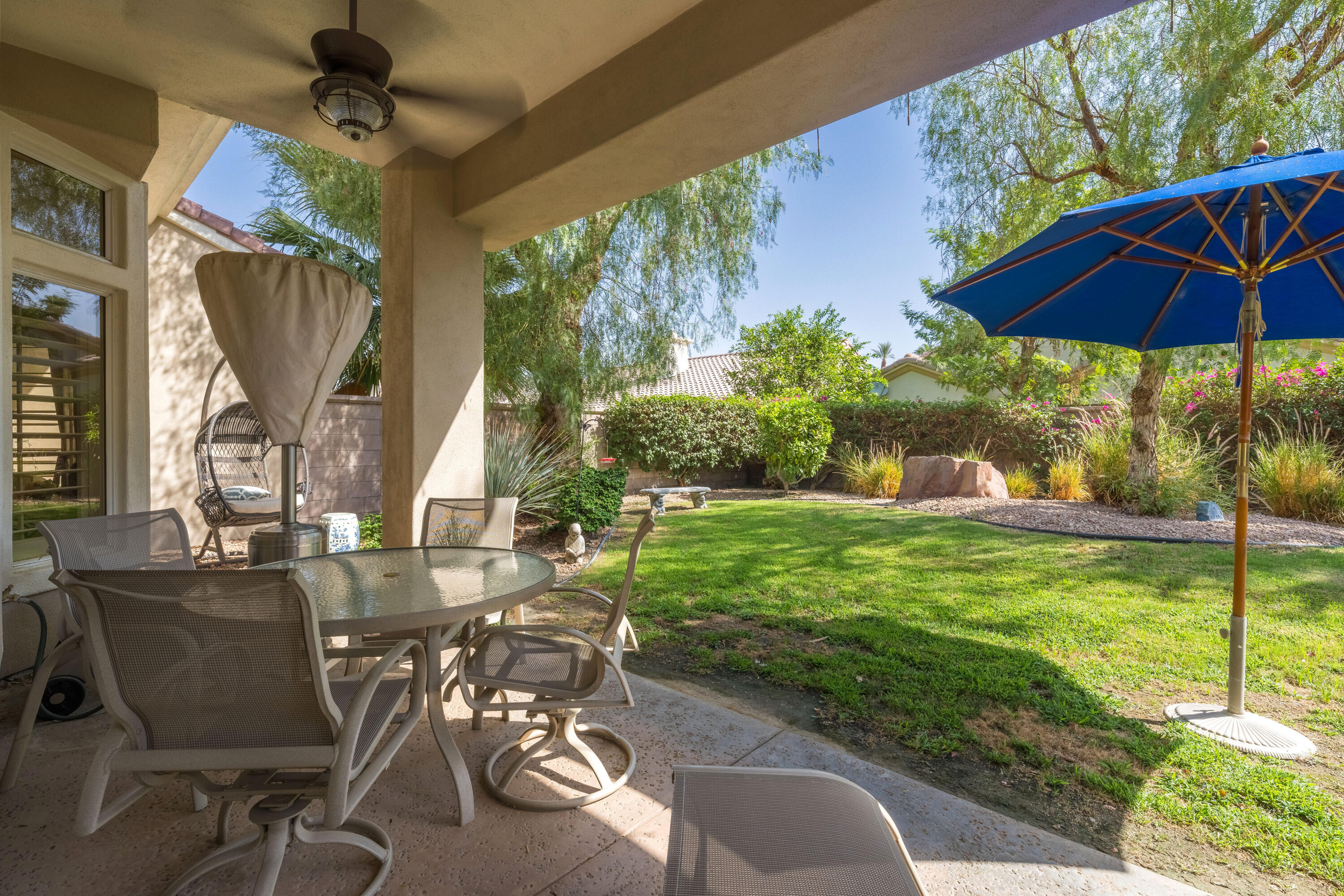 78274 Rainbow Drive Palm Desert, CA 92211 - Photo 4 of 24 a view of a patio with table and chairs under an umbrella