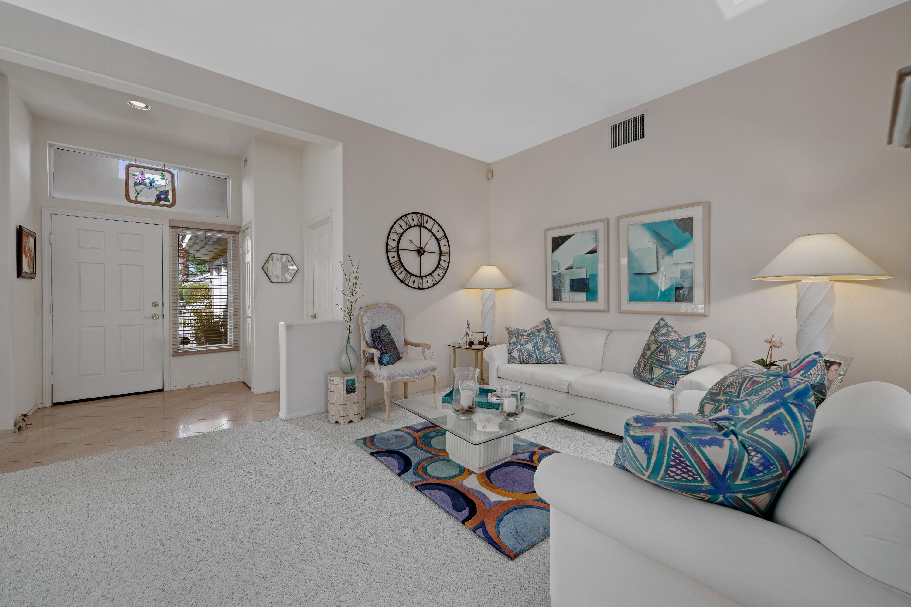 78274 Rainbow Drive Palm Desert, CA 92211 - Photo 9 of 24 a living room with furniture a clock on wall and a window