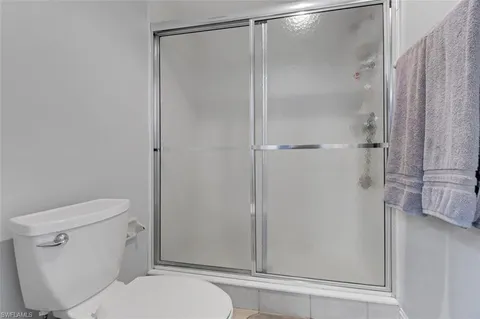 a white toilet sitting next to a shower