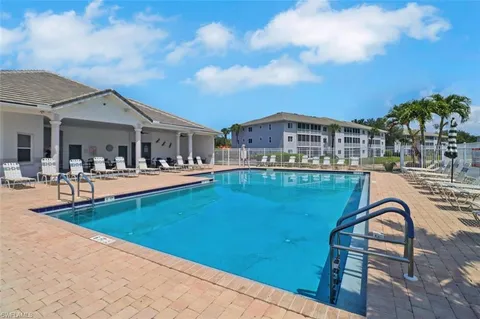 a front view of a house with swimming pool and sitting area