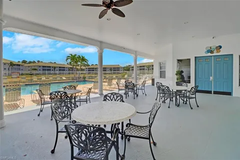 a living room with furniture a bookshelf and a window