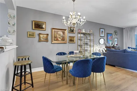 a dining room with furniture a chandelier and window