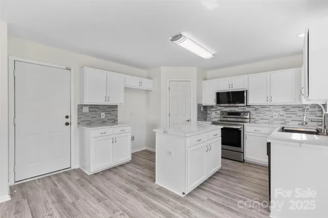 a kitchen with white cabinets stainless steel appliances and sink