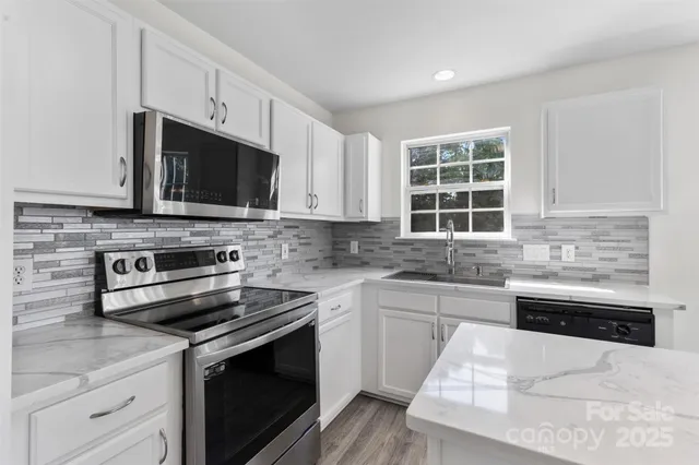 a kitchen with stainless steel appliances granite countertop a stove microwave and sink