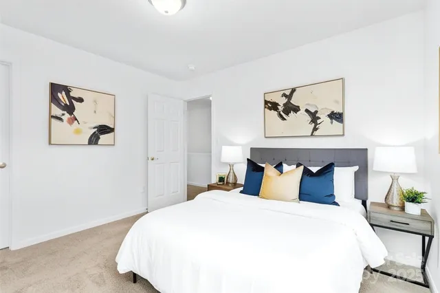 a bedroom with a bed and painting on the wall