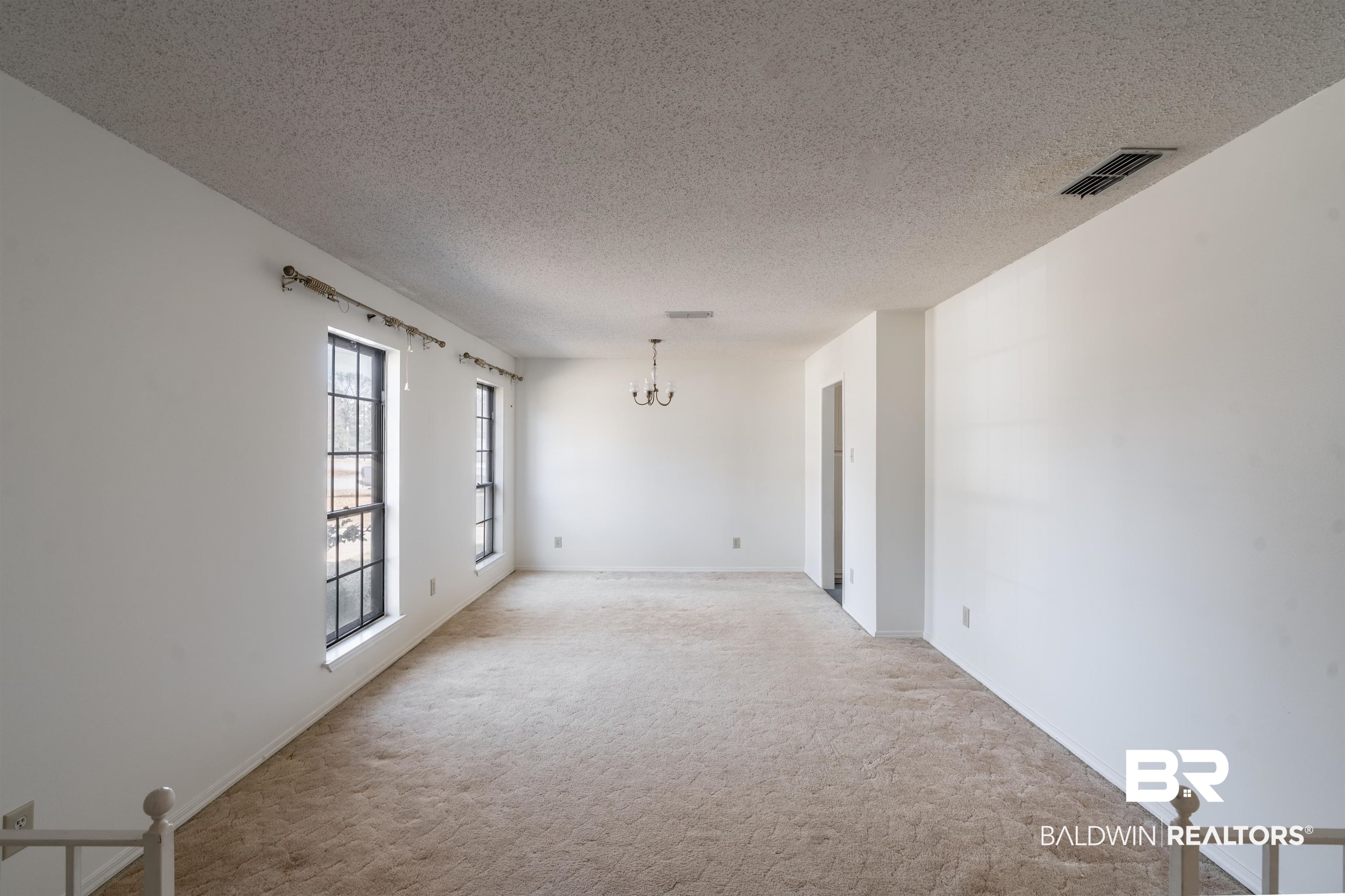 9751 Pine Knoll Road Mobile, AL 36608 - Photo 4 of 36 Spare room featuring a chandelier, a textured ceiling, and carpet