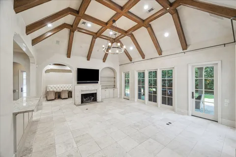 a view of a livingroom with furniture fireplace and windows