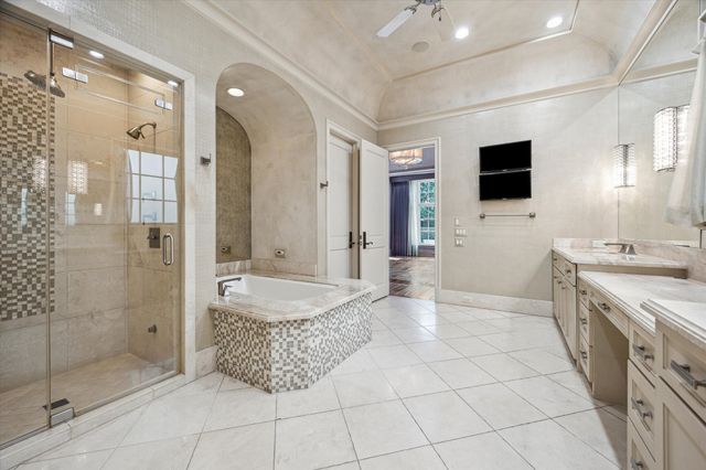 a spacious bathroom with a granite countertop sink a mirror a shower and a bathtub